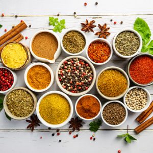 Herbs and spices in bowels over white wooden background. Top view with copy space